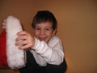 December 2007 ~ Here's Jonah, refusing to wear the Santa hat and laughing at me because he knows I want a picture of him wearing it.  (Age 5)
