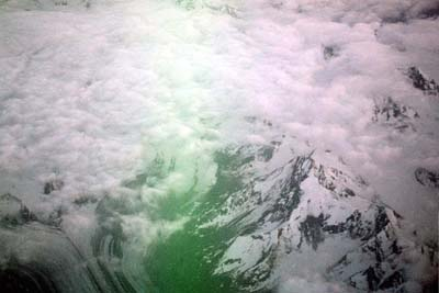 The first glimpse of a mountain peak through the clouds over Alaska.