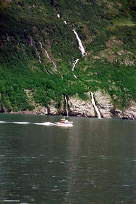 Waterfalls from glaciers and snow above tumble to Passage Canal