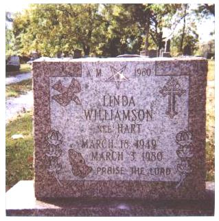 Linda's gravestone with the symbols of her faith, and her life.