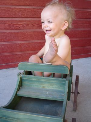 Skyler sitting in a wagon I keep on my front porch