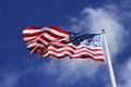 American flag backdropped against a blue sky.