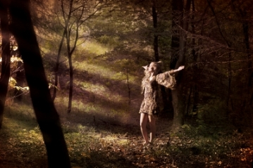 Picture of a woman in a forest wearing a short dress.