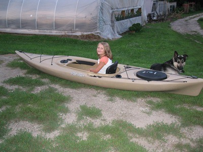 Leah sits in her mom's kayak all ready to go. Our German Shepherd, Bo, is looking on.