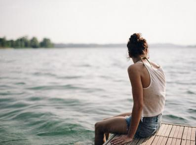 A girl sitting on a pier