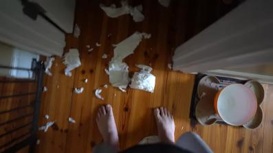 Picture of a bathroom floor covered in pieces of torn up toilet paper.