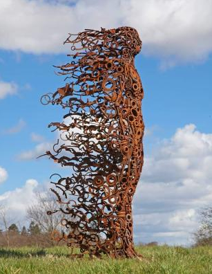 Figure of a woman in branches shaped by the wind.