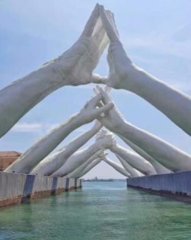 Photo of arms reaching over a gap.