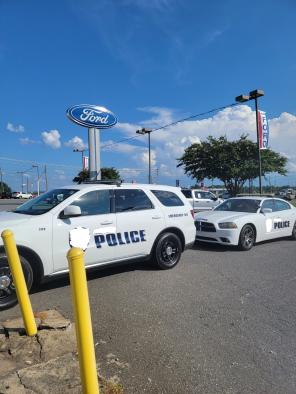 Cops pulling into a Dealership after a call was made about a drunkard making threats.