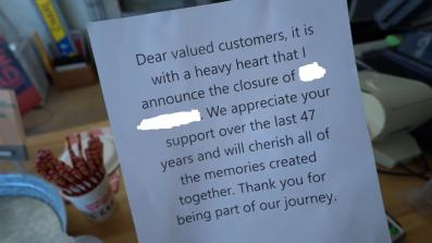 A sign outside of a closed down sandwich shop.