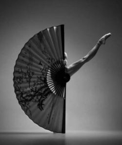 Ballet dancer holding giant fan.