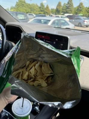 Lardo, holding a bag of chips with very little chips inside!