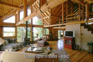 Interior of our New Log Home ~  Our New home, the prow front overlooking mountains.  A two-story great room.  This is a 3 story level custom log home on 60 acres with a log barn to match, four stalls and tack room with run outs, all acreage fenced and cross fenced.  We moved in Nov 21, 2009, right before Christmas. 